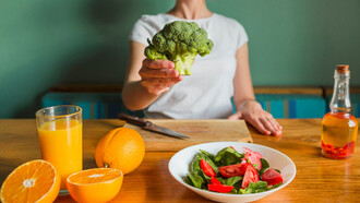 A women showcasing a variety of rich nutrient vegetables and fruits  providing a more successful cleanse