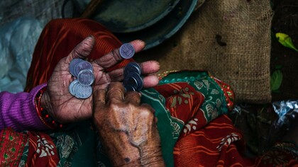 A person holding some money in their hands. Exploitation is further exacerbated by the intersectional nature of the feminization of poverty