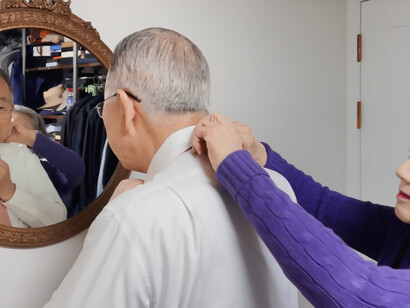 Ban Ki-moon puts on his tie in front of the mirror