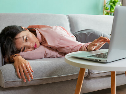 Thoughtful businesswoman resting on a sofa, contemplating technology and modern digital life
