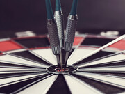 Darts hitting the bullseye, symbolizing success