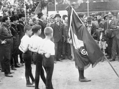  Benito Mussolini, ottobre 1931. Davanti a lui, alcuni bambini della "gioventù fascista"