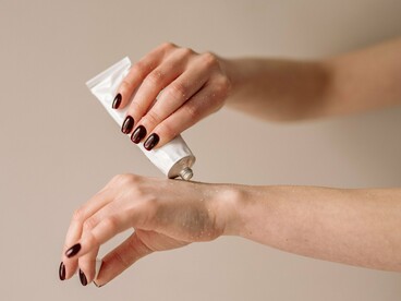 A hand cream being applied thoughtfully, reflecting how simple barrier support can be more valuable than an overloaded skincare routine
