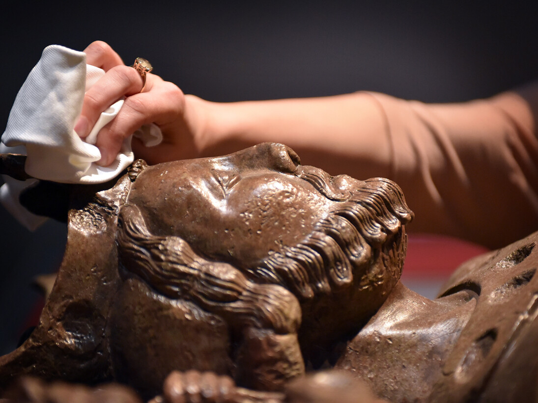 Dusting a replica of King Johns tomb which resides in Worcester Cathedral for the opening of Magna Carta: Law, Liberty, Legacy at the British Library. Photography © Clare Kendall