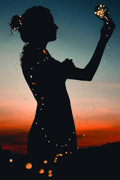 A solitary figure stands beneath a crescent moon at twilight, gazing at the stars as a glowing path stretches into the distance