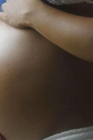 A pregnant black woman taking ownership of her womb