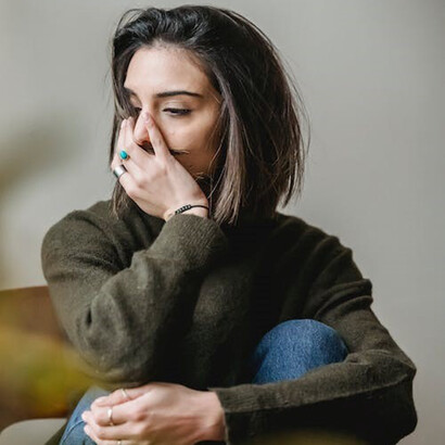 A girl wearing a green sweater appears visibly distraught