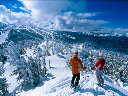 Una pareja de esquiadores, preparándose para realizar el descenso