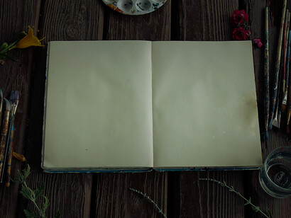 An open diary, with blank pages and paint brushes. Pick a hobby, paint and journal. You can also keep a stress journal, and write about things that bother you