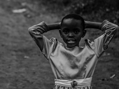 With hands on her head, this young girl symbolises the burden of uncertainty and the desperate need for support, as she navigates the complexities of her daily struggles