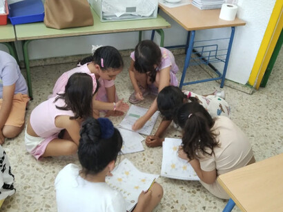 Los niños estudian en el suelo para refrescarse de las altas temperaturas en las aulas. Colegio público en Huelva, España