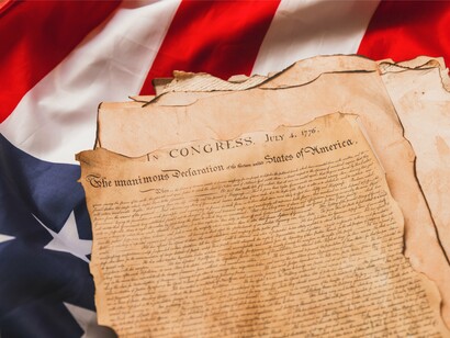 The Declaration of Independence carefully displayed with the American flag, reflecting the values of liberty, justice, and equal rights