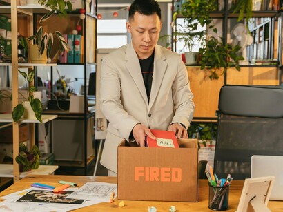 A man packing his belongings after being laid off, representing the emotional toll of workforce automation