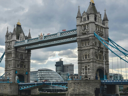 The iconic Tower Bridge spanning the River Thames in London, framed by moody, overcast clouds