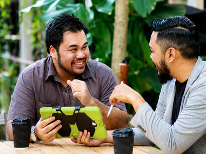 Two friends enjoy a coffee while talking about their concerns in a cozy café surrounded by greenery