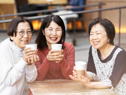 A group of middle-aged Korean women shares a joyful moment in a cozy coffee shop, their laughter filling the air as they enjoy each other's company