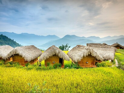 Traditional bamboo houses in a green landscape, illustrating how natural materials meet human needs