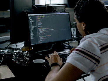 A tech employee working on a computer at an office desk