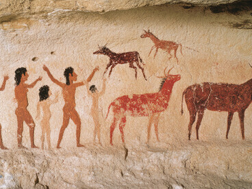 Archaeological cave paintings alongside reconstructions of prehistoric social groups, offering insight into early human society