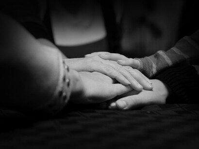 Una familia coloca sus manos en medio de la mesa en señal de unión