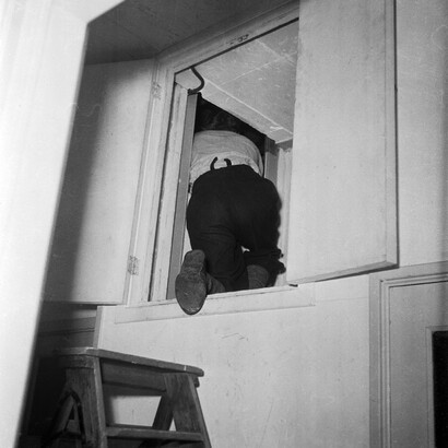Onderduiker Joop Kuijt kruipt in schuilplaats, Oranje Nassaulaan 15, Amsterdam, 1945. Courtesy of Foam © Charles 
Breijer / Nederlands Fotomuseum