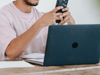 A man conducting a paid search on his phone and laptop