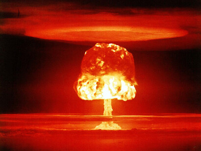 The immense detonation at a Nevada nuclear test site in 1957 epitomises the destructive legacy of nuclear weapons, highlighting the deep-rooted distrust that perpetuates their existence