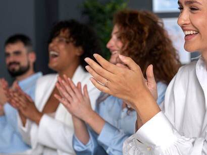 Business professionals applauding at a community recognition awards ceremony, celebrating team achievements and diverse appreciation programs led by community leaders