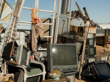 A growing pile of discarded televisions and obsolete electronics, representing the mounting global challenge of electronic waste