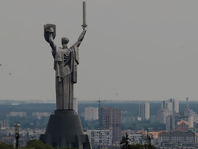 A captivating view captures the essence of a statue featuring a soldier, wielding a shield, set against the backdrop of Kyiv, Ukraine