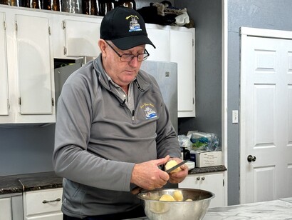 Eugène coupe des pommes de terre pour son ragoût de poisson traditionnel dans sa cuisine à Terre-Neuve. Avec l’aimable autorisation d’Ingenium. Musée de l’agriculture et de l’alimentation du Canada. Photo prise par Heritage Newfoundland et Labrador