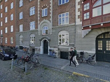 El paso de una arquitectura que se transmitía y se deformaba con el tiempo a otra que se ejecuta en un presente continuo, siempre actualizable, siempre optimizable. En una calle y vereda de piedras, 2026, Copenhague, Dinamarca