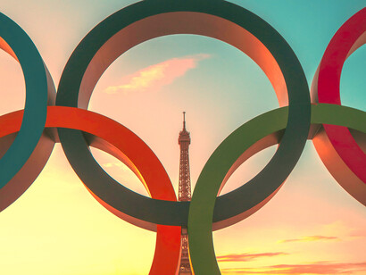 The Olympic rings with the Eiffel Tower in the background; The 2024 Olympics represent a blend of historical significance and contemporary innovation 
