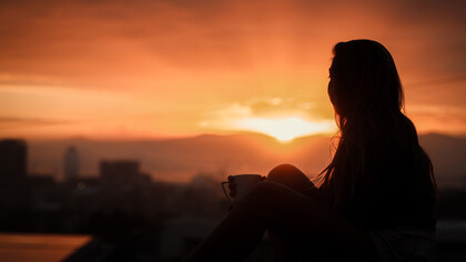 Silueta de una mujer mirando hacia el atardecer