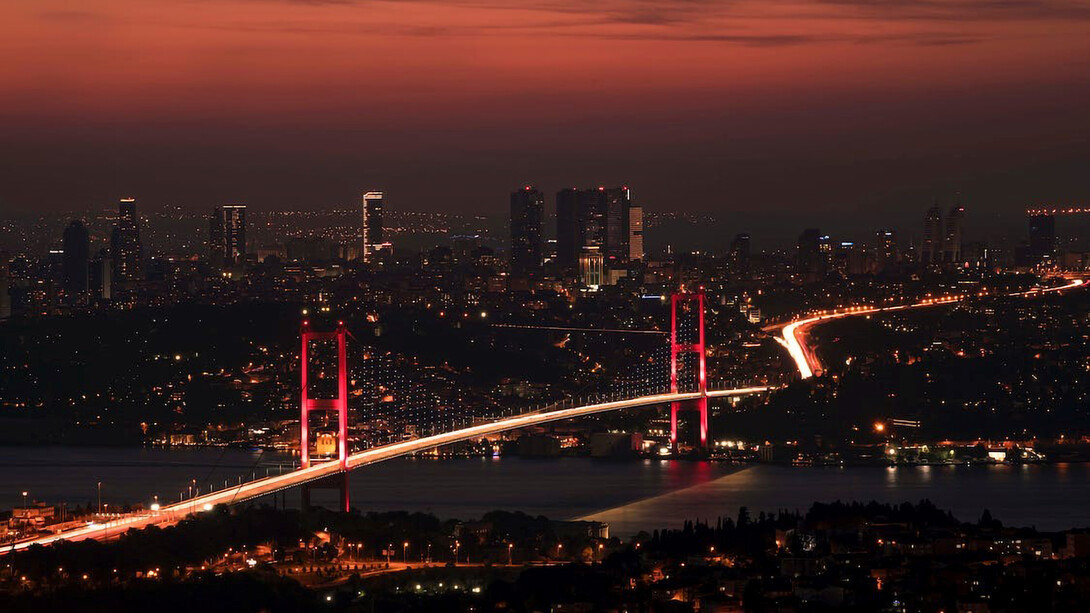 The Bosphorus Bridge comes alive with a mesmerizing glow as night falls over Istanbul
