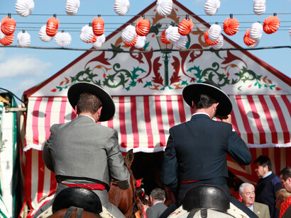 Feria de Abril de Sevilla. Jinetes vestidos de corto paseando por la Feria