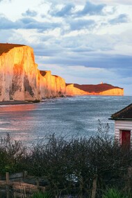 The Seven Sisters Cliffs glowing at sunset by the sea, United Kingdom