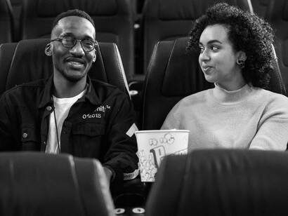 Casal trocando olhares no cinema antes do filme começar