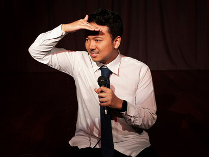 A stand-up comedian on stage, captivating the audience in a buzzing comedy club