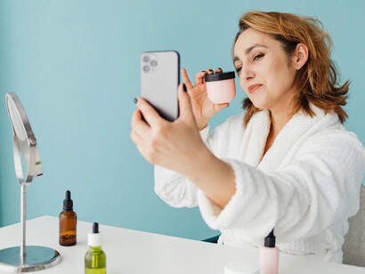 Señora sacándose fotos con productos de belleza