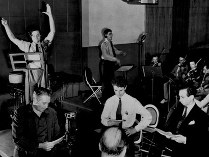 Dramatización de «La guerra de los mundos» en la radio en 1938 por OrSon Welles (brazos levantados) y el resto de actores, con músicos incluidos