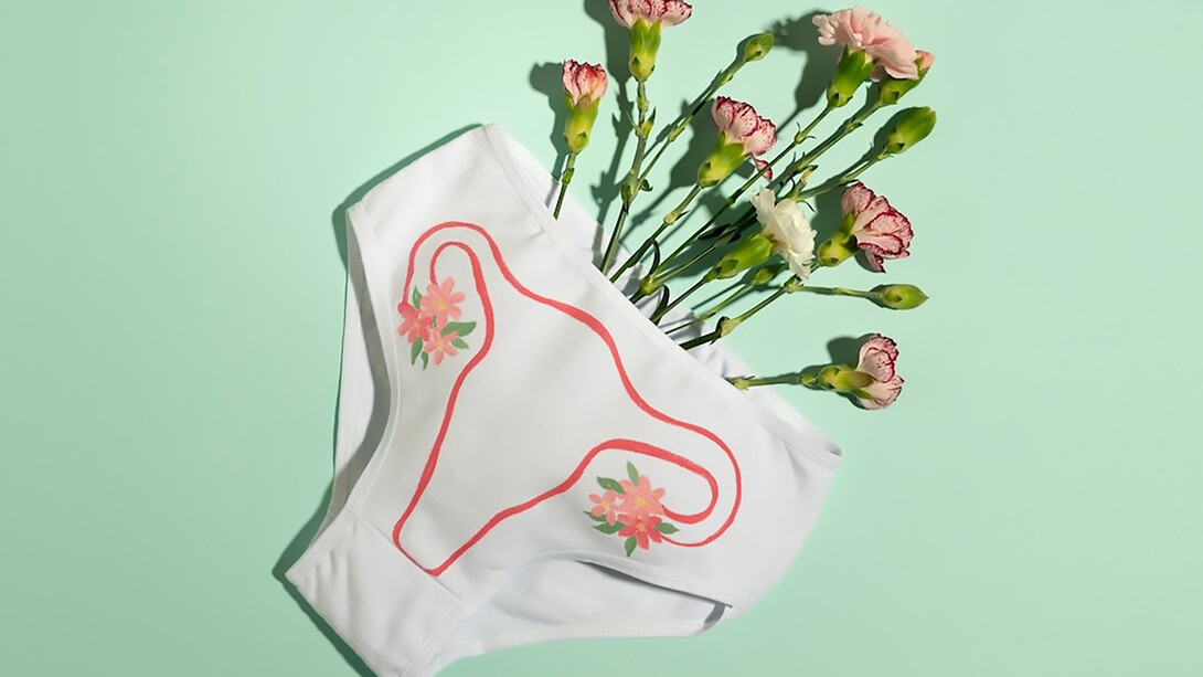 On white underwear, flowers highlighting the importance of menstrual health awareness and personal care