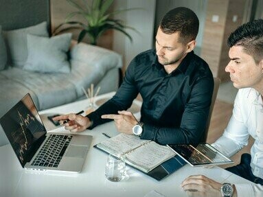 Homens avaliam índices econômicos. A economia austríaca é profundamente influenciada pela praxeologia, a teoria da ação humana desenvolvida por Mises. A praxeologia parte do princípio de que os indivíduos agem racionalmente para alcançar objetivos, buscando melhorar sua condição e satisfazer suas necessidades. As escolhas dos indivíduos no mercado são vistas como os principais motores da atividade econômica, e a análise de como essas escolhas afetam o sistema econômico como um todo é essencial para a compreensão da economia