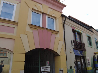 The building faces the adjacent street with a façade of a different stylistic character, yet equally striking, Pécs, Hungary