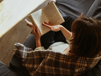 Professora de literatura lê livro sobre os clássicos literarários brasileiros