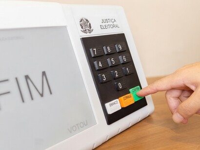 A voter presses the confirm button on an electronic voting machine during Brazil’s presidential elections