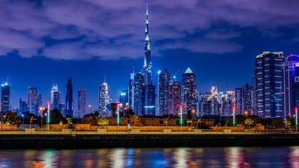 The Burj Khalifa in Dubai among dense urban towers at night, highlighting how engineering mastery supports vertical expansion