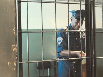 Policial fecha o portão da cela na cadeia