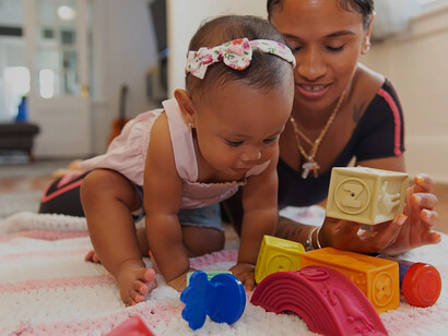 Engaged in joyful interaction, an individual playfully engages with a baby on the floor