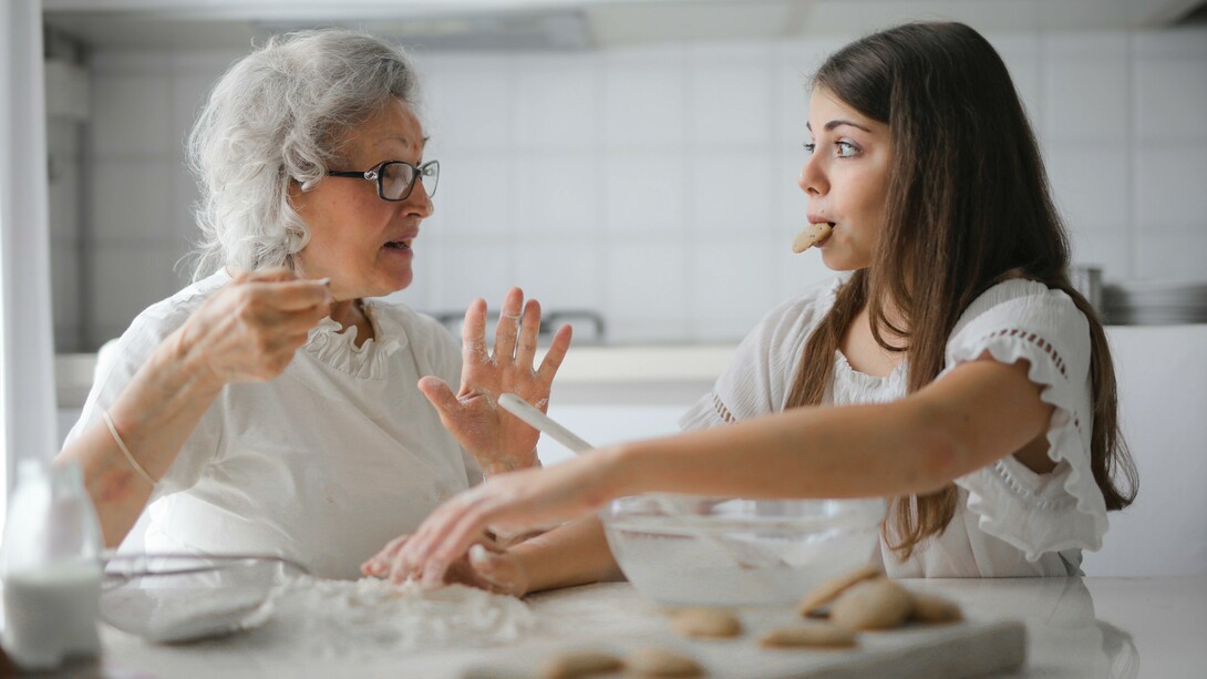 A grandmother and a granddaughter making cookies together 